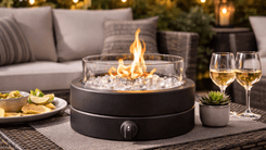 Amazon Basics 14-inch round propane fire pit burning on outdoor patio table at night